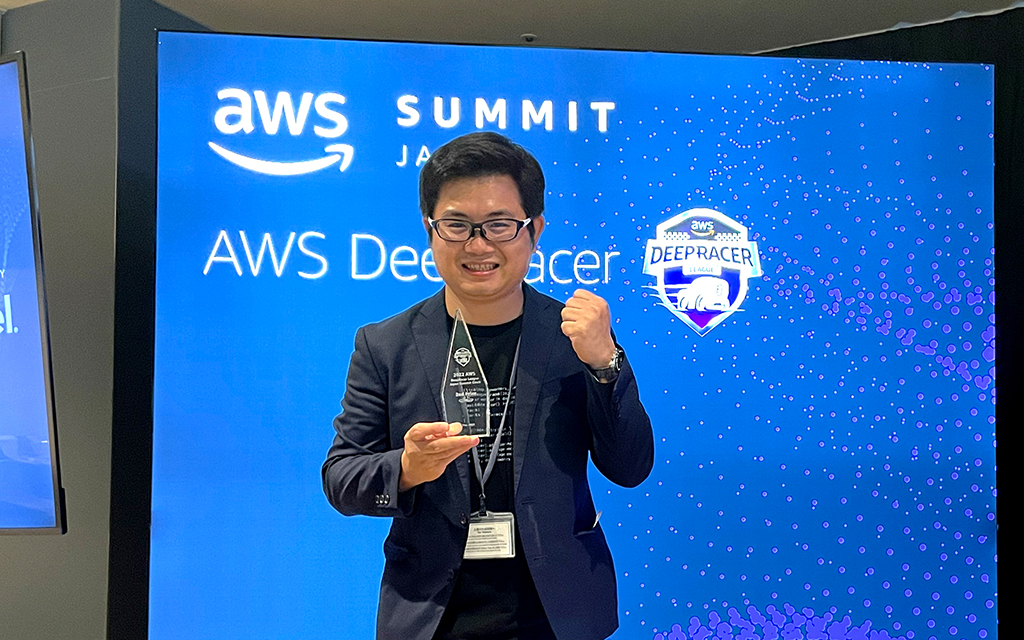 「AWS DeepRacer リーグ」日本大会で2位となり、トロフィーを手にガッツポーズをするグエン ディン ホアンの写真