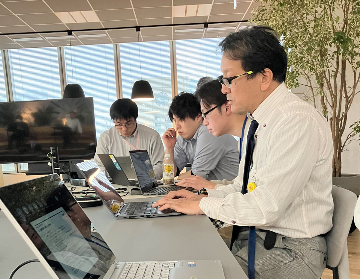 4名の社員がオンライン会議でOpenAI APIチームの発表を聞く様子